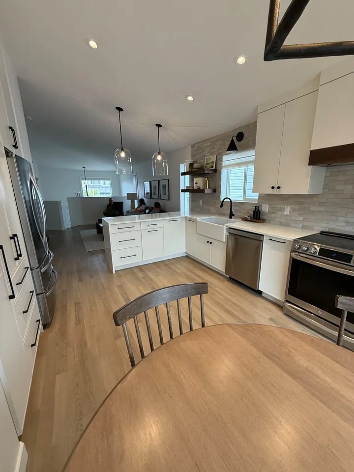 Kitchen with white cabinets, stainless appliances and hardwood flooring