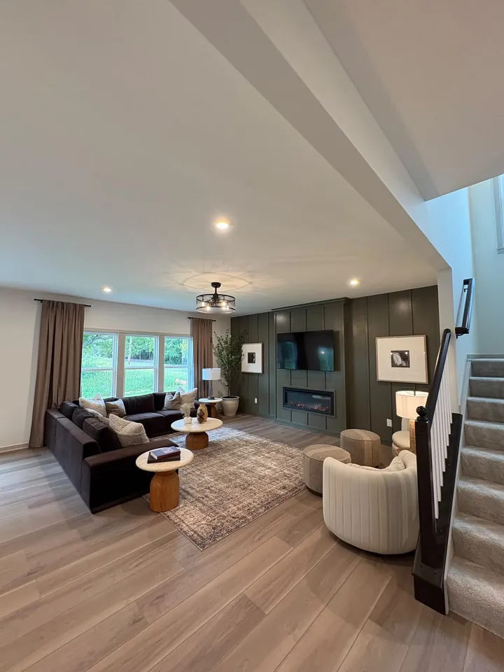 Living room with a wood feature wall, fireplace and a staircase beside it