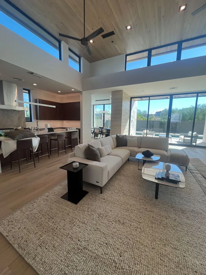 Open living room with a vaulted wood ceiling, large windows and a sectional sofa